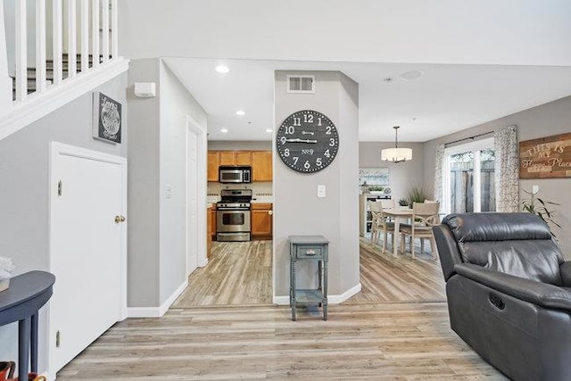 living room with a notable chandelier and light hardwood / wood-style flooring