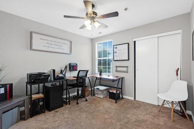 carpeted home office featuring ceiling fan