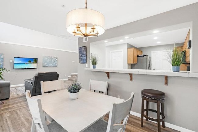 dining area with an inviting chandelier and light hardwood / wood-style floors