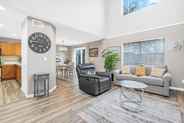 living room featuring an inviting chandelier and light wood-type flooring