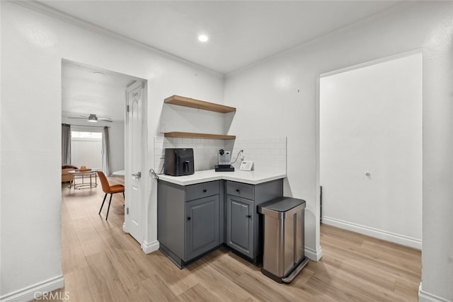 kitchen featuring gray cabinets, tasteful backsplash, ceiling fan, crown molding, and light wood-type flooring