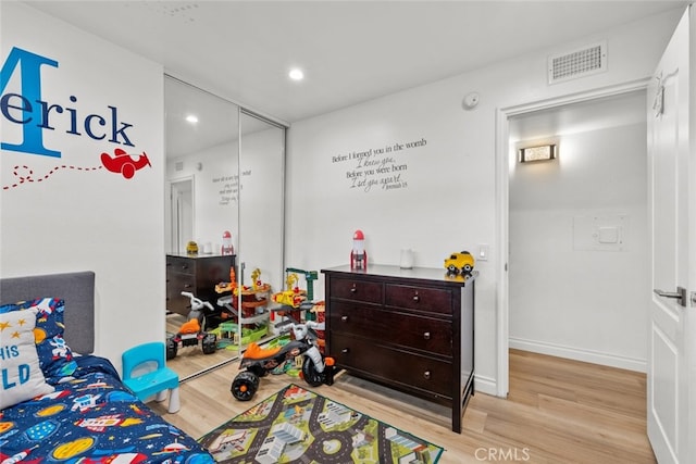 bedroom with a closet and light hardwood / wood-style flooring