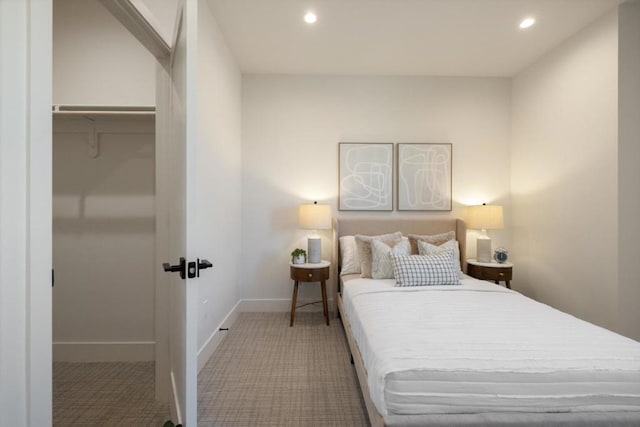 carpeted bedroom featuring a walk in closet and a closet