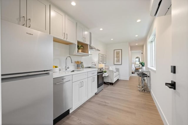 kitchen featuring stainless steel appliances, white cabinetry, sink, and light hardwood / wood-style floors