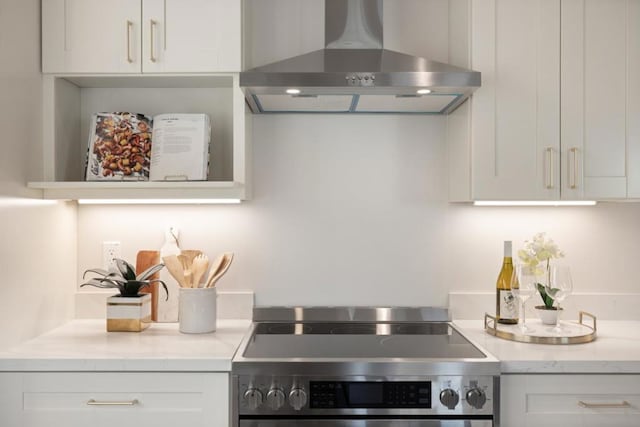 kitchen featuring electric stove, white cabinetry, and wall chimney exhaust hood