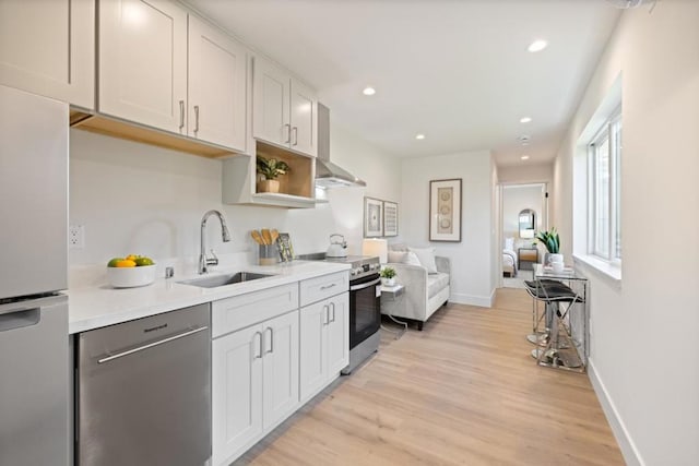 kitchen featuring sink, light wood-type flooring, white cabinets, and appliances with stainless steel finishes