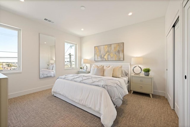 bedroom with light colored carpet and a closet