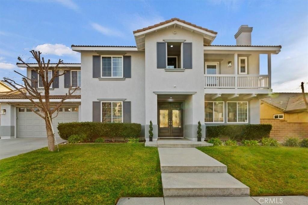 mediterranean / spanish-style home featuring a garage, a front lawn, and french doors