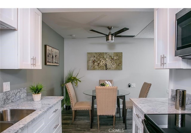 dining space with ceiling fan, dark hardwood / wood-style flooring, and sink