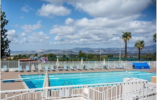 view of pool with a mountain view and a diving board