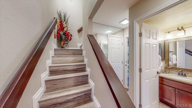 stairs with sink and wood-type flooring