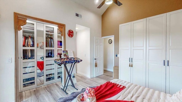 bedroom with ceiling fan, high vaulted ceiling, a closet, and light hardwood / wood-style flooring