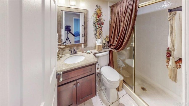 bathroom featuring an enclosed shower, vanity, tile patterned floors, and toilet