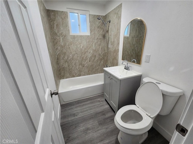 full bathroom featuring wood-type flooring, toilet, vanity, and tiled shower / bath