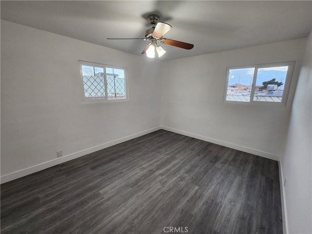 unfurnished room featuring dark wood-type flooring and ceiling fan