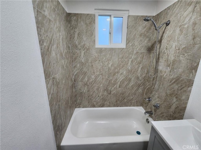 bathroom with tiled shower / bath and vanity