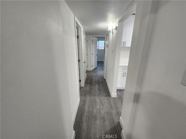 corridor featuring dark hardwood / wood-style floors and a textured ceiling