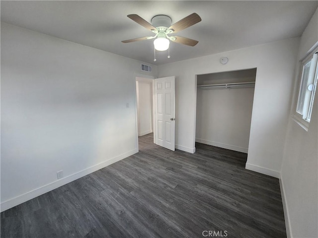 unfurnished bedroom with dark hardwood / wood-style flooring, a closet, and ceiling fan