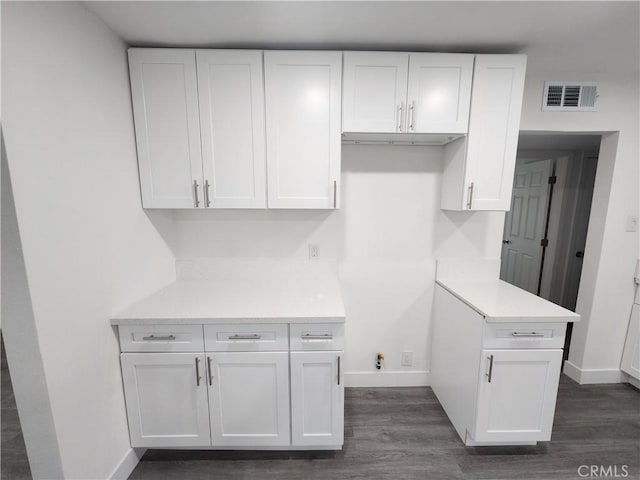 kitchen with dark wood-type flooring and white cabinets