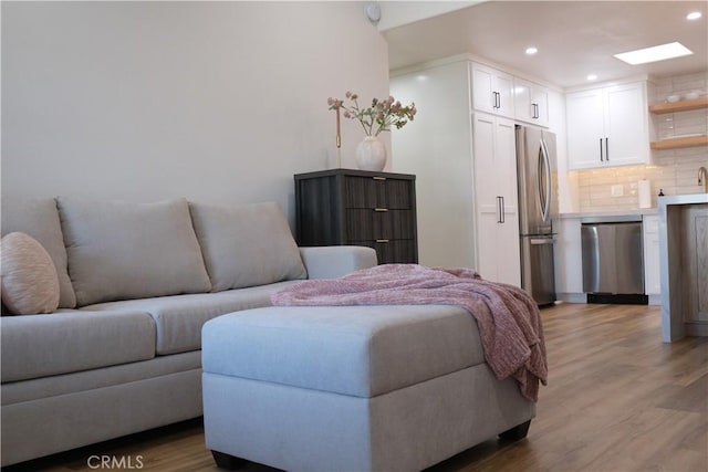 bedroom with stainless steel refrigerator, a closet, and light hardwood / wood-style flooring