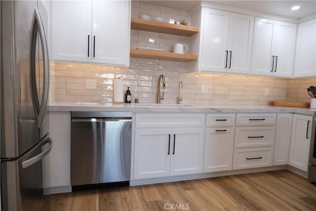 kitchen featuring tasteful backsplash, stainless steel appliances, and white cabinets