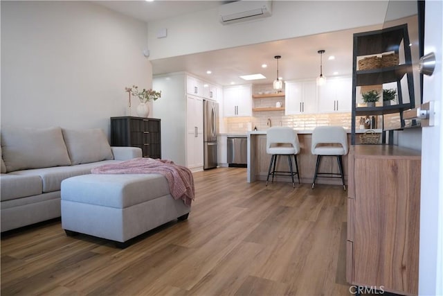 living room featuring hardwood / wood-style flooring and a wall mounted AC