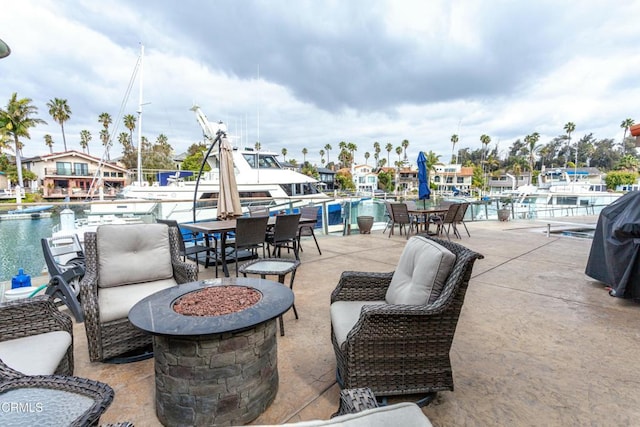 view of patio / terrace featuring a water view, a community pool, and a fire pit