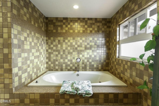 bathroom with tiled bath and tile walls