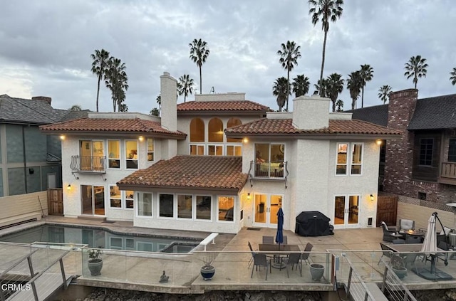 back of house with a patio, a balcony, and french doors