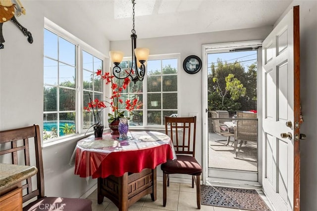 sunroom featuring a healthy amount of sunlight and a chandelier