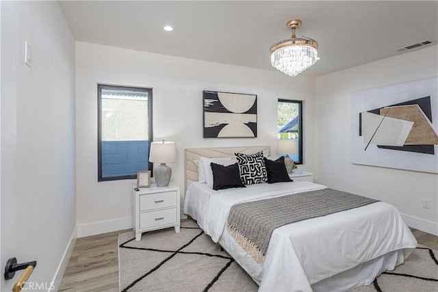 bedroom featuring a chandelier and light wood-type flooring