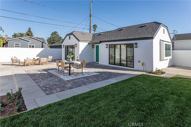 back of house with an outdoor living space, a patio, and a lawn