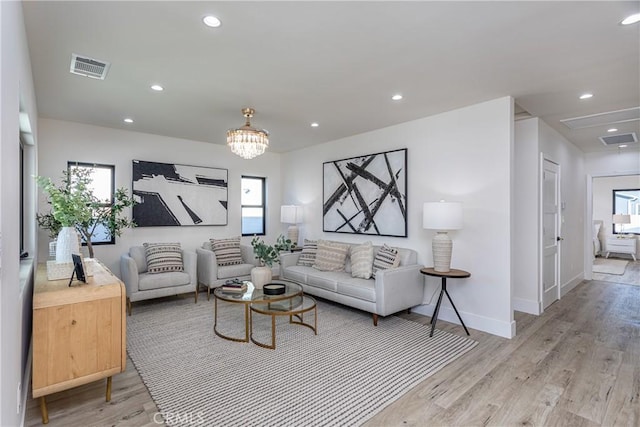 living room featuring a chandelier and light hardwood / wood-style flooring