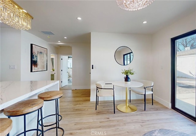 dining room featuring an inviting chandelier and light hardwood / wood-style flooring