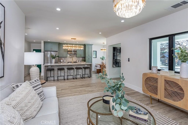 living room featuring an inviting chandelier and light hardwood / wood-style flooring