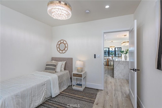 bedroom featuring hardwood / wood-style flooring and a chandelier