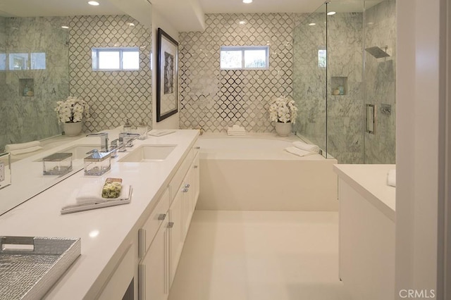 bathroom featuring vanity, a healthy amount of sunlight, and separate shower and tub