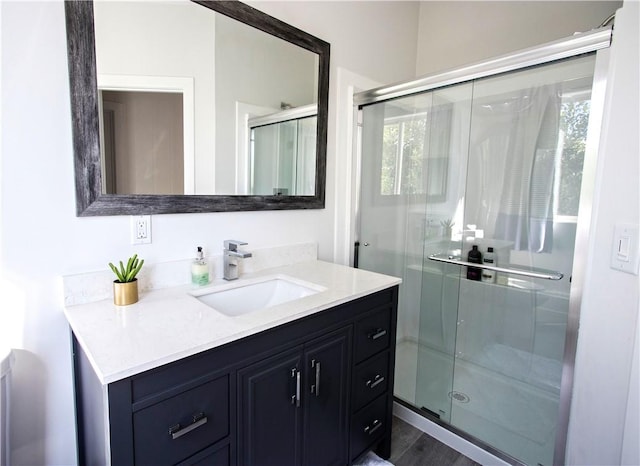 bathroom with vanity, wood-type flooring, and an enclosed shower