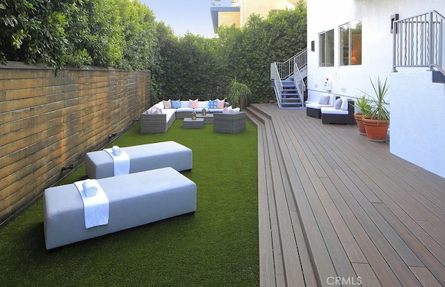 deck with an outdoor living space and a yard