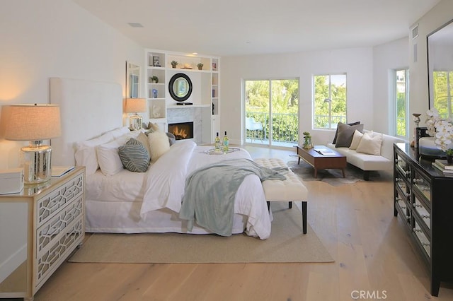 bedroom featuring wood-type flooring and a high end fireplace