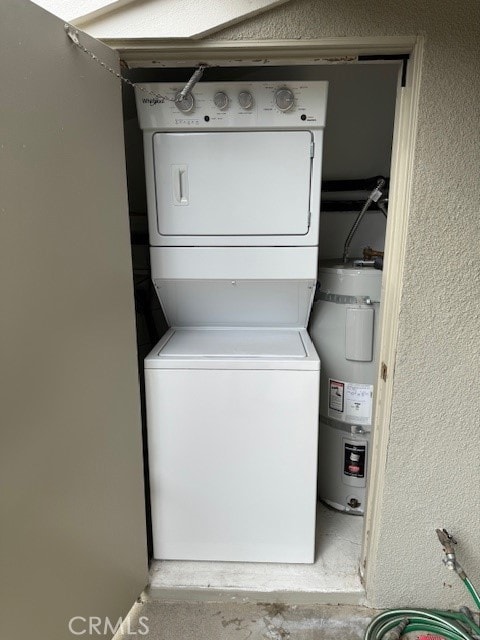 laundry room with secured water heater and stacked washer and clothes dryer