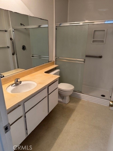 bathroom with walk in shower, vanity, and toilet