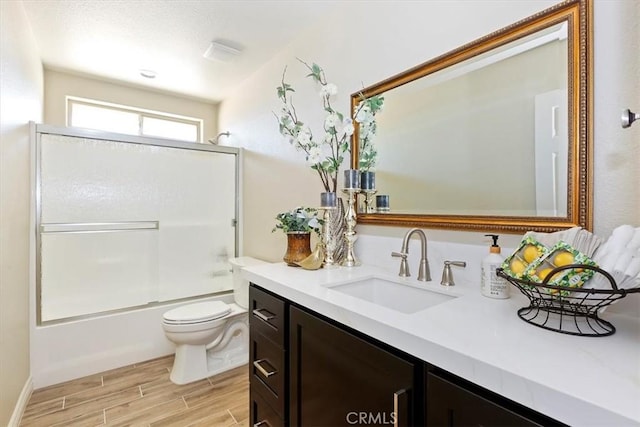 full bathroom with toilet, vanity, and shower / bath combination with glass door