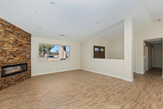 unfurnished living room featuring vaulted ceiling and light wood-type flooring