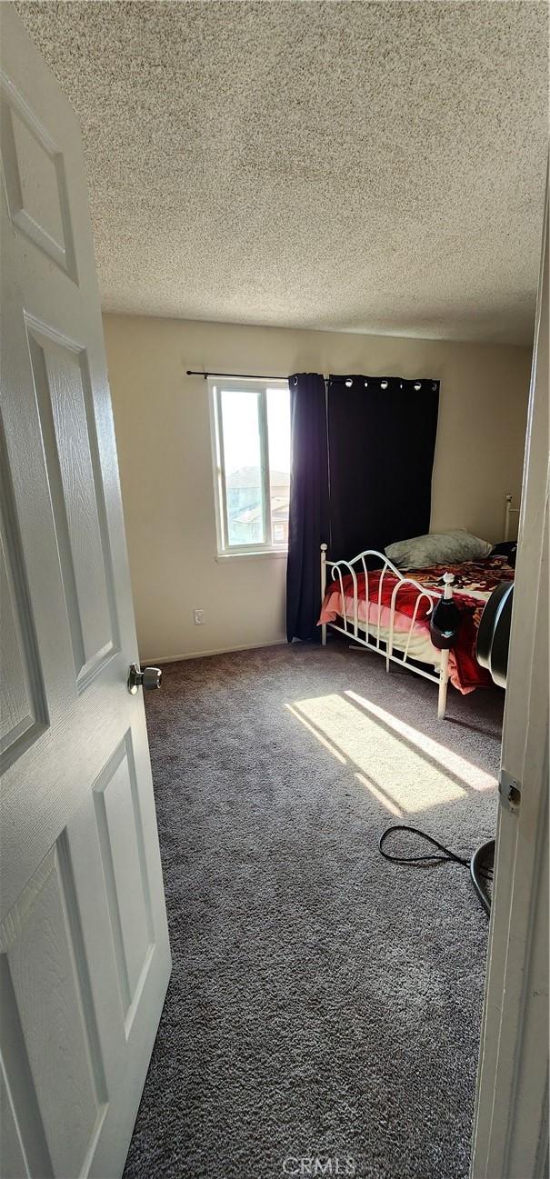 bedroom featuring carpet and a textured ceiling