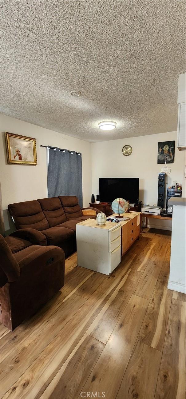 living room with light hardwood / wood-style flooring and a textured ceiling