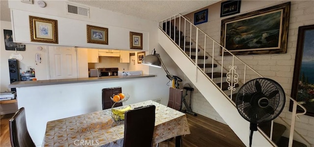 dining area with hardwood / wood-style floors and a textured ceiling