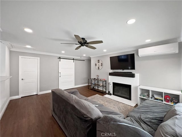 living room featuring dark hardwood / wood-style floors, a wall mounted AC, ceiling fan, crown molding, and a barn door