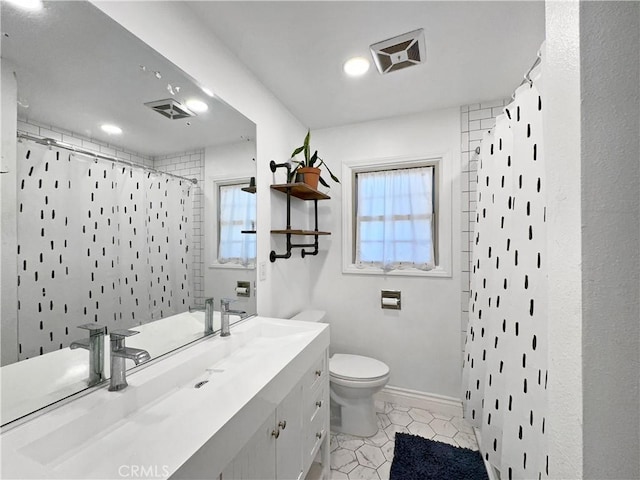 bathroom with vanity, tile patterned flooring, toilet, and walk in shower