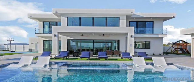 rear view of property with a playground, a pool with hot tub, ceiling fan, and a patio area